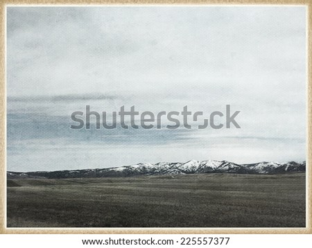 A valley with a snow-covered mountain in the distance.
