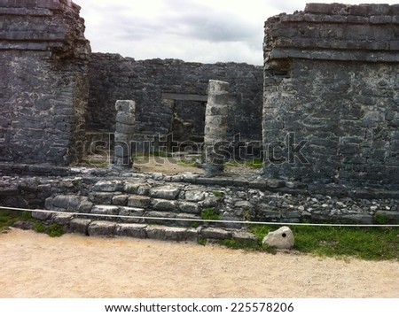 Two stone pillars are nearly surrounded by stone walls.