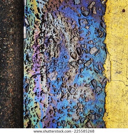 Oil stains making a rainbow pattern on the road.