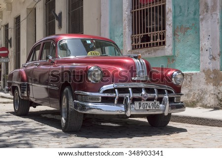 HAVANA, CUBA - JUNE 13, 2014: Red old american car parked in front of a colonial house in Old Havana.