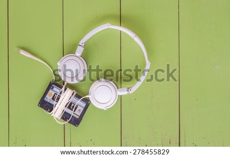 Cassette tape and head phone on green color wood board