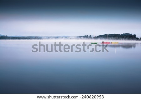 Boats on the lake with morning fog