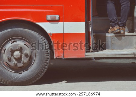 A man entering a bus. Watch Your Step. Side view.