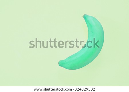 Fashion light green banana on green background. Bright color. Minimalism.