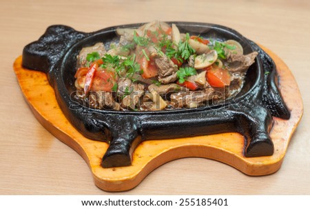 Stew beef with vegetables on a cast iron bull form base