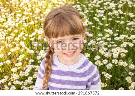Cute five years old girl at camomile field