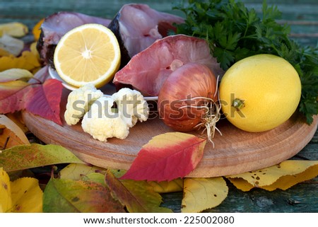 Portions of river fish with lemon, parsley and cauliflower on the yellow leaves