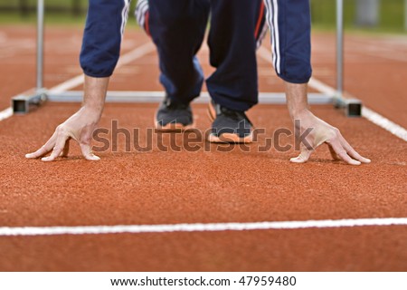Athlete in sprint position on a running track