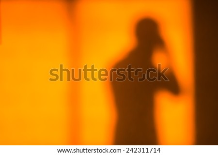 Human Shadow on wall in sunset light amber color back ground