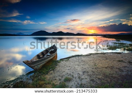 A fisherman\'s traditional boats at the lakeside is a beautiful sunset view