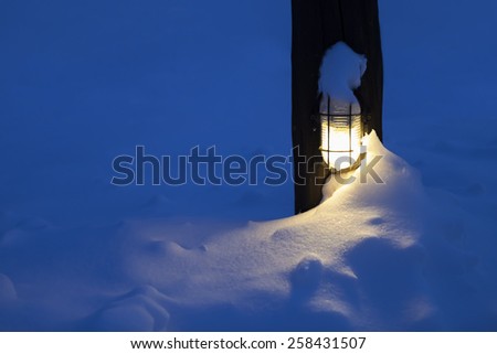 Outdoor lamp covered in snow.