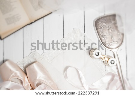 Vintage classic composition with antique mirror, binoculars, pointes and book on a white wooden background shabby chic style dance theme