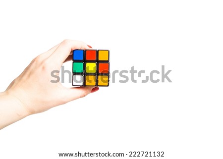 KIROV, RUSSIA - OCTOBER 06, 2014: Rubik\'s cube in hand holding it on the white background. Rubik\'s Cube invented by a Hungarian architect Erno Rubik in 1974.