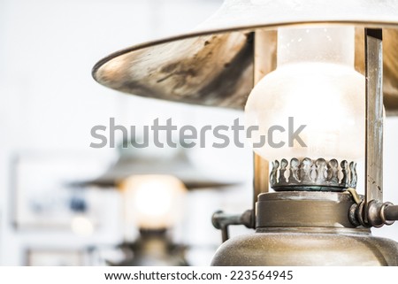 Old retro vintage metallic decorative lamp with patina hanging on the ceiling of a russian tavern interior. Rustic style electric lamp imitated antique rustic kerosene lamp