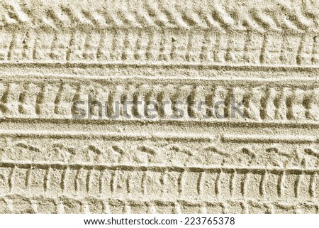 Ribbed tyre traces on grey silver dry sand. Background for articles about traveling, transport and ecology