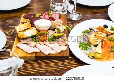 different kinds of meat on a wooden board in russian restaurant