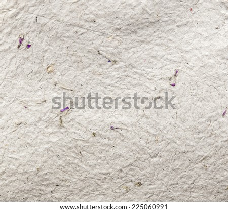 Homemade hand crafted textured paper with inclusions of gold foil and floral petals on a grey background. Useful for scrapbooking and greeting cards