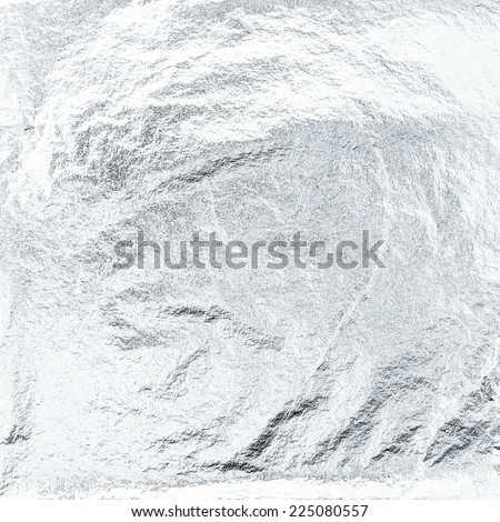 Thin sheet of silver leaf background with shiny uneven surface