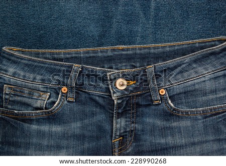 Old shabby indian blue denim jeans pants with pockets and metal rivets. Background for fashion design and identity