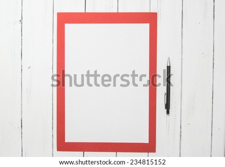 Blank sheet of paper on a red sheet of paper isolated on a white wooden background with black pencil