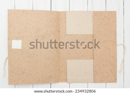 Old craft vintage paper folder opened on a white wooden background