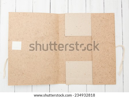 Old craft vintage paper folder opened on a white wooden background