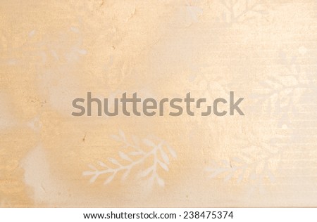 Golden pattern with branches and leaf silhouettes golden spray color on a corrugated paper carton