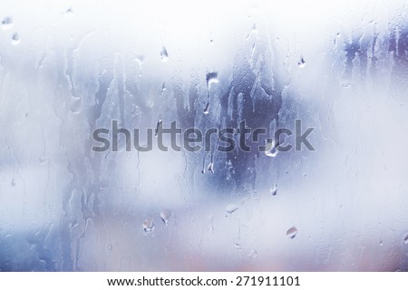 Bright window glass with steam and drops. Colorful backdrop with light leaks