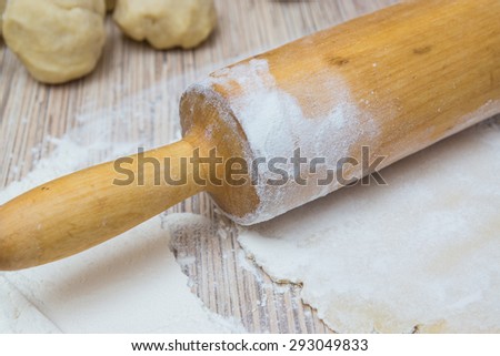 rolling pin with dough and flour on a table. Preparing a baking