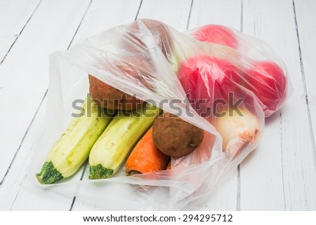 Vegetables packed in a plastic bag on a white wooden table