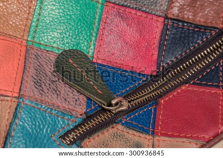 Stylish bright leather bag of square colorful patches. Close-up photo with pocket and zipper