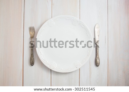 Served table with an antique table, silver folk and knife on a white wooden table