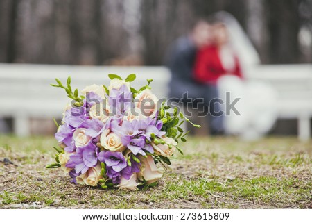 blurred silhouette newlyweds behind wedding bouquet