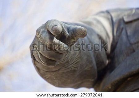 Finger pointing at you (at looking, viewer). Granite monument hand