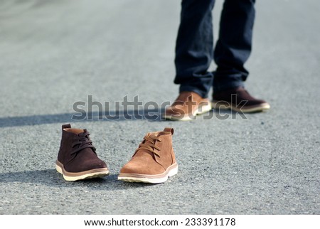 Human foot with brown leather shoes and jeans