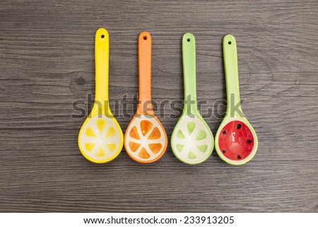 Spoons of different colors on wood background