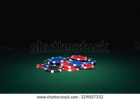 Poker chips on table in casino with black background