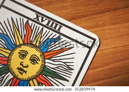 Tarot card sun for clairvoyance and divination on wooden table