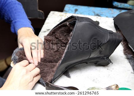 Footwear production by human hands in a shoe factory.