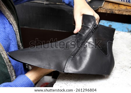Footwear production by human hands in a shoe factory.