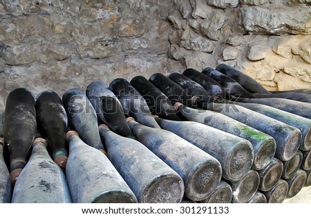 The ancient bottles of wine in the ancient cellar. The unique vintage wine in the cellar.Old bottles of wine in rows in wine cellar..