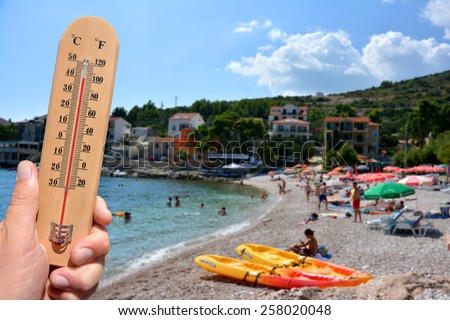 A thermometer scale shows extreme high temperatures during a heat wave and beach in background. Skin cancer warning