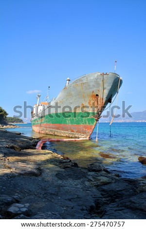 old cargo ship stranded on stone shore