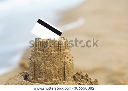 Sand castle tower with credit card. Payment for holidays vacation concept