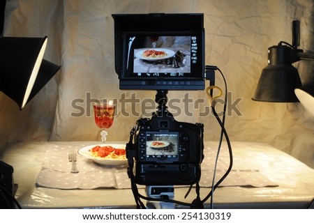 Food photographer with camera and monitor.