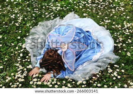 The matter of dreams. Child hiding her face on flower field.