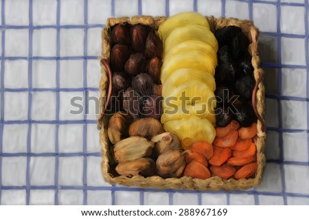 Basket of dried fruits. Dried fruit basket  on a towel background. Hand digital manipulation like old instant film manipulation technique.