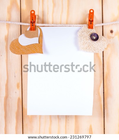 Paper sheet hanging on clothesline with clipping path and paper heart background for Valentines day