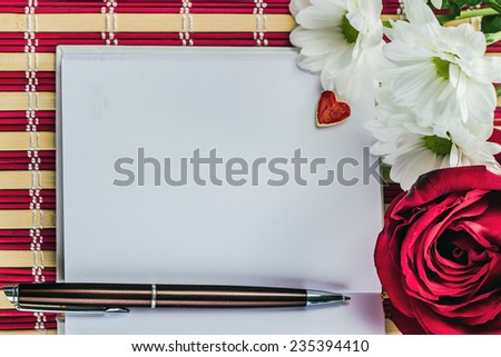 open notepad with pen on a background of flowers