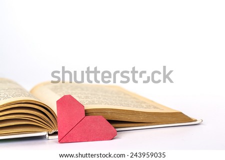 Open book with paper heart isolated on white background